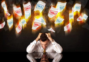 Depressed businessman sitting under falling papers