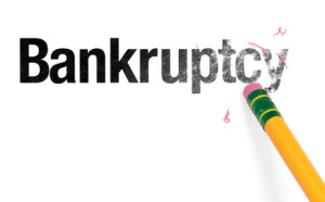 Close up of a yellow pencil erasing the word, 'Bankruptcy.' Isolated on white.