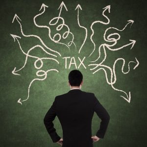 Concept of businessman thinking with arrows coming from tax